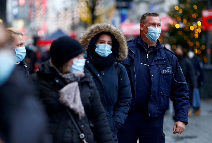 A police officer checks if people wear masks a main shopping district as the spread of the coronavirus disease continues in Cologne, Germany, on December 1 2021.