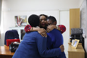 Pinetown Girls' High school principal Sibongile Njapha comforts two pupils at the school on Wednesday. The girls were friends of Ayakha Jiyane, a grade 11 pupil whose body was founding hanging on Tuesday evening.