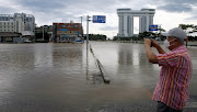 A man takes a photo of a submerged parking lot struck by Typhoon Maysak in Gangneung, South Korea, September 3, 2020.  