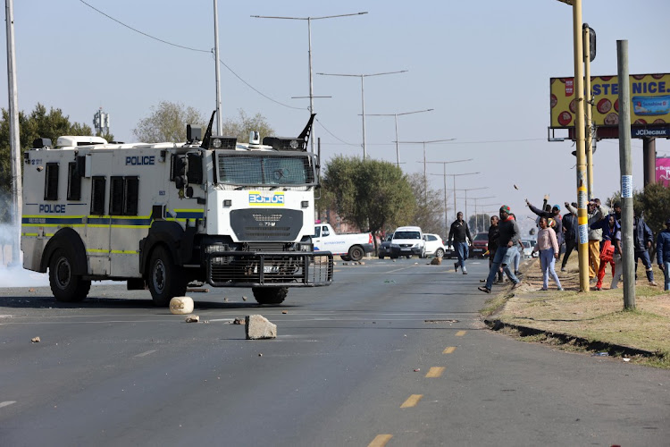 Diepkloof hostel residents throw stones at police during a protest over water and electricity.