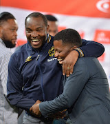 Cape Town City head coach Benni McCarthy shares a light moment with Mamelodi Sundowns' media officer Thulani Thuswa during the Absa Premiership match between the two teams at Loftus Versfeld Stadium on December 19, 2017 in Pretoria. City won 1-0. 