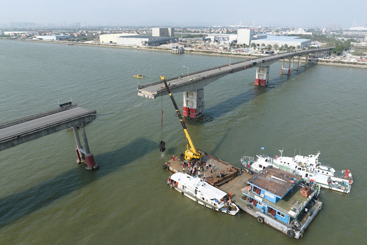 A drone view shows rescue workers at the site where a container ship hit Lixinsha bridge, plunging vehicles into the waters, in Guangzhou, China, on February 22. Picture: CHINA DAILY/REUTERS