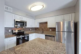 Kitchen with a middle island, white cabinets, and stainless steel appliances