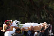 Mourners carry the body of a victim during a burial ceremony for victims of the mosque attacks at the Memorial Park Cemetery in Christchurch, New Zealand, on March 22 2019.