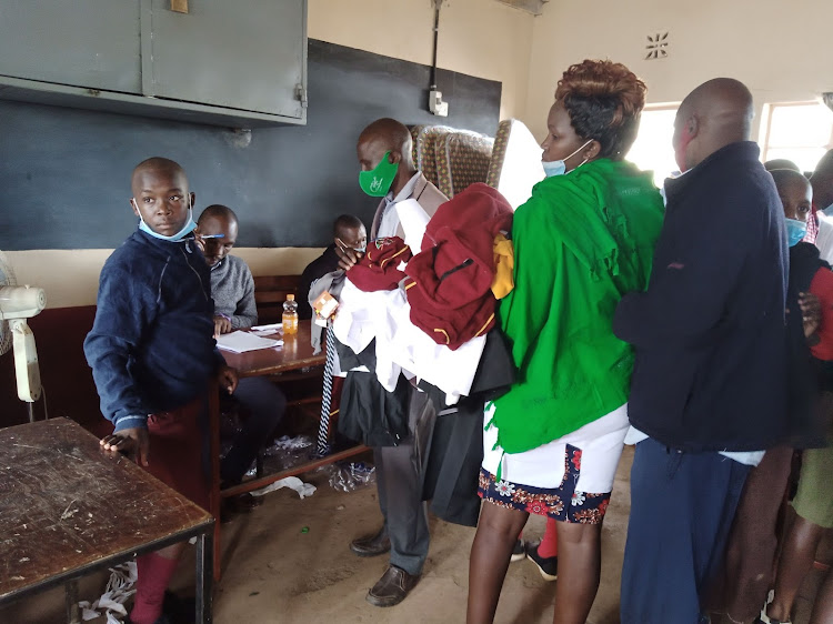 Parents assist their new Form 1 students as they are issued with school uniforms at Kerugoya boys.