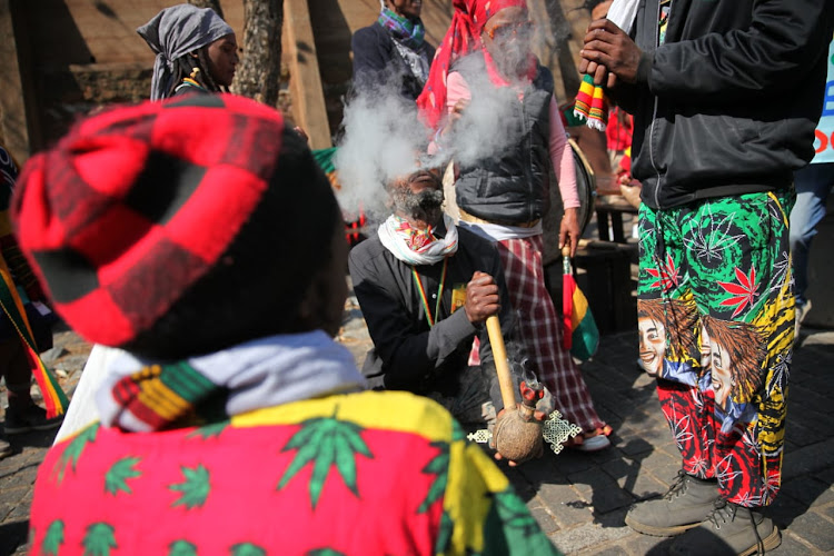 Members of the rastafarian community smoke marijuana outside the Constitutional court in Johannesburg where the court will rule on the states appeal of the Western Cape Judgment stating that South Africans can grow and smoke cannabis for recreational use at home.