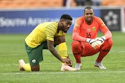 Bafana Bafana captain Thulani Hlatswayo (L) and his deputy Itumeleng Khune look on during the 2019 Africa Cup of Nations qualification match between South Africa and Seychelles at FNB Stadium on October 13, 2018 in Johannesburg.   