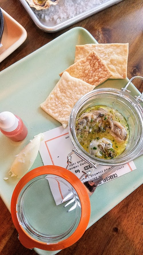 Lafitte's, a hidden bar located on the 2nd floor of The Waiting Room in NW Portland offering cocktails that are champagne and absinthe forward and a small bites menu that includes this dish, Cold Smoked Oyster with goat milk butter, saltines and hot sauce