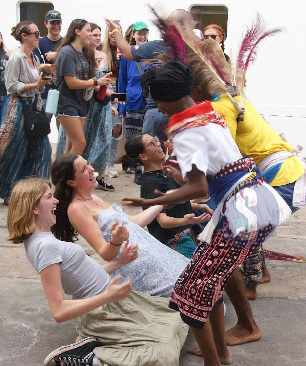 Tourists enjoying traditional dance after their vessel docked.