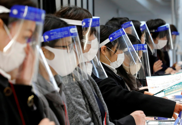 Staff wearing protective face shields amid the coronavirus disease (Covid-19) outbreak work at a reception desk at an exhibition centre in Tokyo, Japan, January 13, 2021.