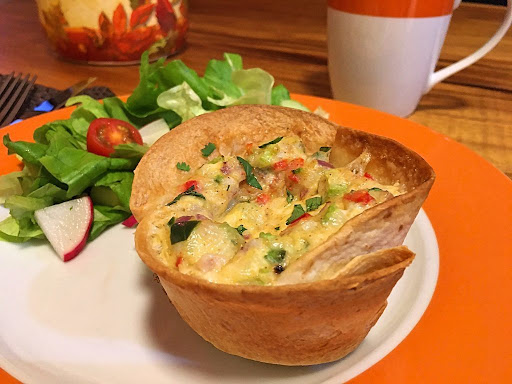 A gorgeous individual quiche in a tortilla served with a green salad