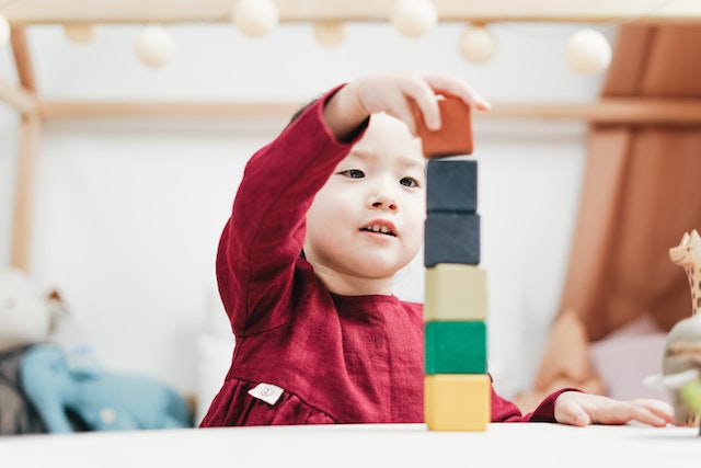 young child playing with wooden blocks