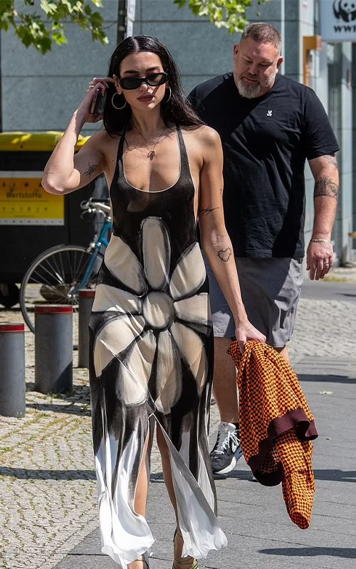 The female singer wears a daring cut-out dress on the street