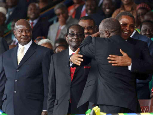 Tanzania's President elect John Magufuli embraces his predecessor Jakaya Kikwete during his inauguration ceremony at Uhuru Stadium in Dar es Salaam as Rwanda's Kagame (not pictured), Uganda's Yoweri Museveni and Zimbabwe's Robert Mugabe look on, November 5, 2015. /REUTERS