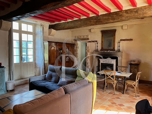 Living room with fireplace and exposed beams in this luxury property for sale in Saint-Gilles-Croix-de-Vie ($1,475,090 - 373 m²)