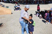 Evelyn Dibaga comforts her emotional daughter Dinah on the child's first day in grade R at Cosmo City Primary in Diepsloot.