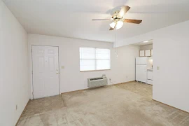 Entry and living area with front door, window with blind, kitchen entry