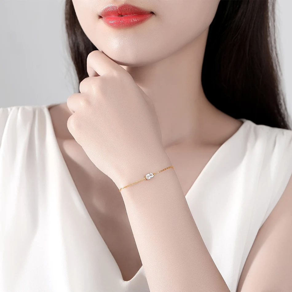 Pulseira feminina com zircônia prateada e cruz incrustada, banhada a ouro 14K, um acessório elegante e brilhante.