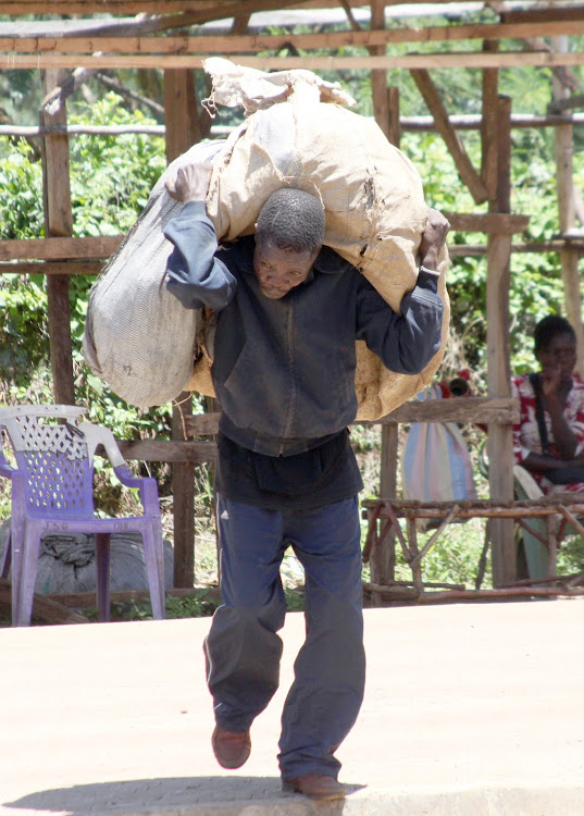 A man carries luggage to a store after the Kisumu government ordered all traders to close business and go home.