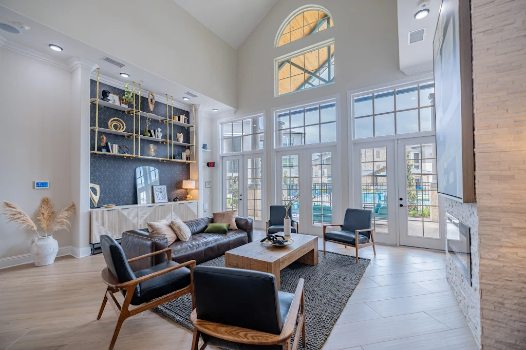 Community clubhouse featuring tall ceilings, large windows, built in shelving, and modern decorations