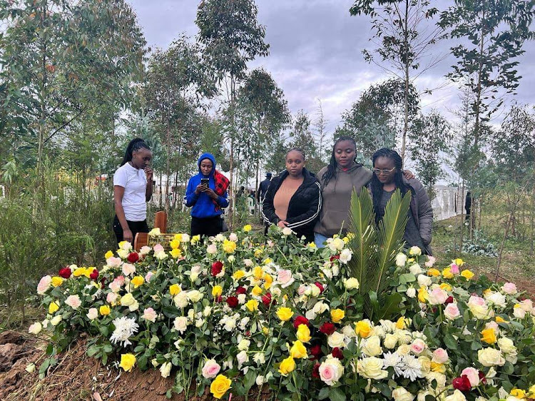 His friends pose for a photo by his grave site.