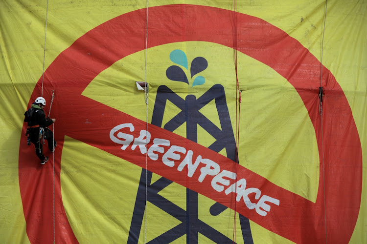 A Greenpeace activist hangs from an oil tank at the Hellenic Petroleum refineries in Aspropyrgos near Athens, Greece.