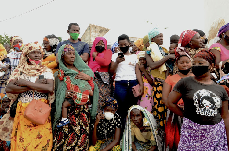 People wait for friends and relatives as a ship carrying more than 1,000 people fleeing an attack claimed by Islamic State-linked insurgents on the town of Palma, docks in Pemba, Mozambique.