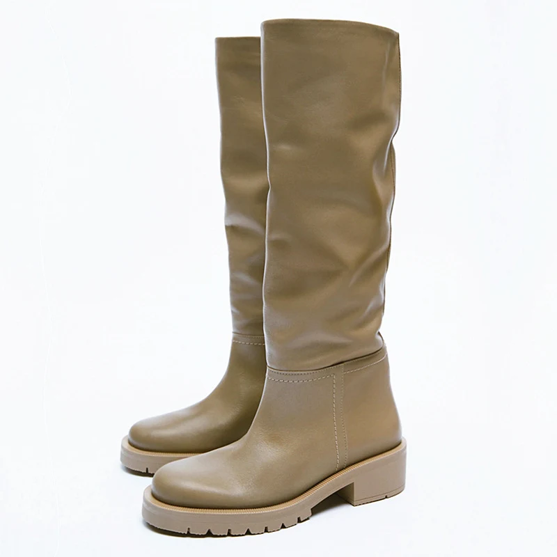 Zandbruine leren laarzen met platte ronde neus en tot de knie hoog voor een stijlvolle en comfortabele look.