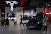 Employees assist customers in a Tesla store in Wuhan, Hubei Province, China.