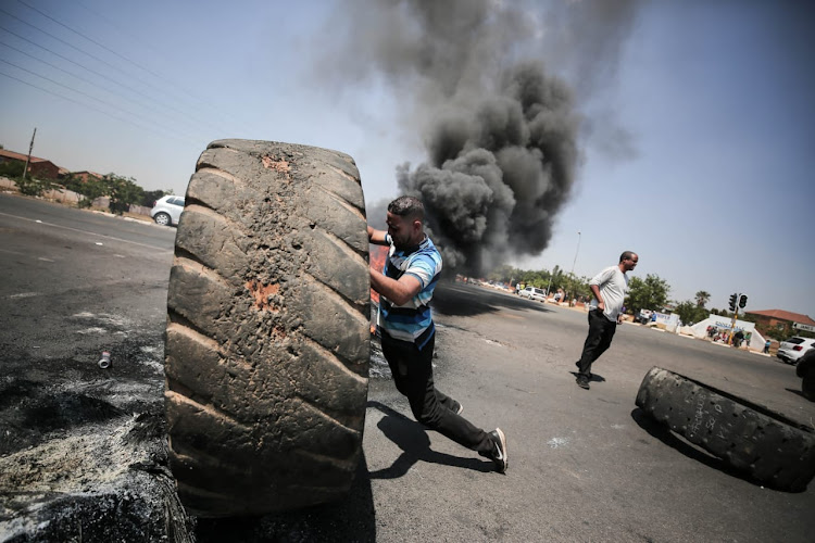 Residents block off the road with tyres in Ennerdale, south of Johannesburg, during a protest over crime, drugs and gangsterism in the area.