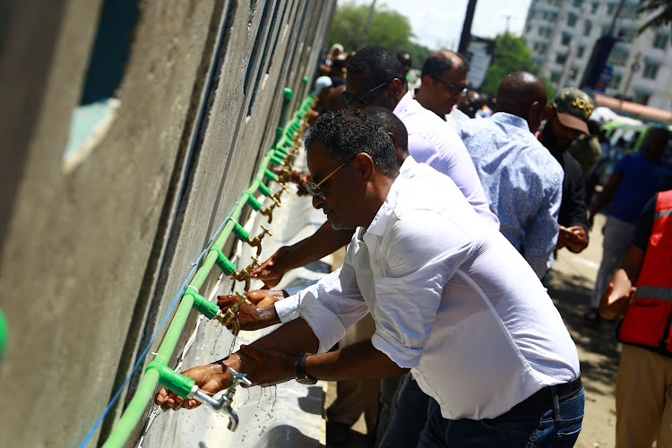 Mombasa county water and sanitation executive Tawfiq Balala washes his hands at the Likoni ferry crossing channel on Friday.