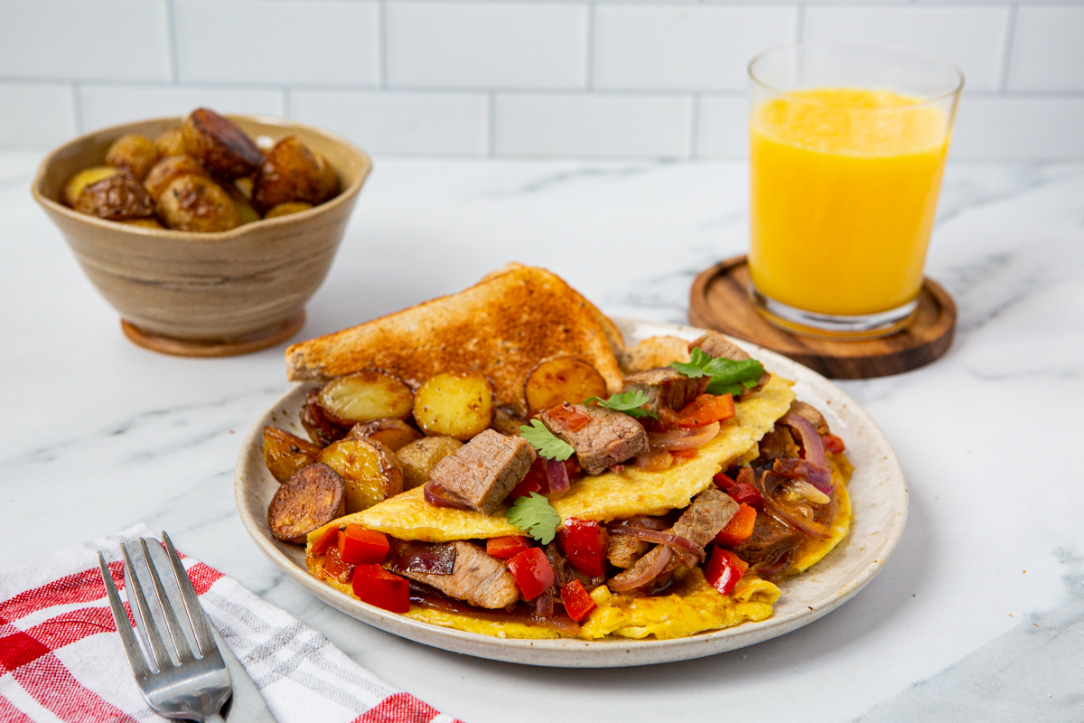 steak omelette served with juice and potatoes
