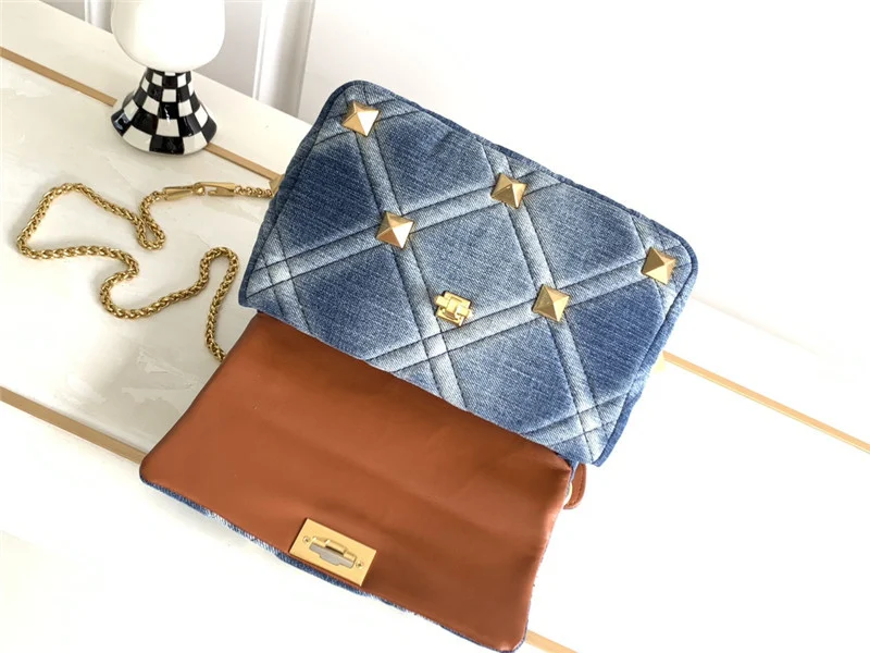 Bolso de mezclilla con piel de vaca, remache grande, ideal para transportar tus esenciales diarios con estilo y durabilidad.