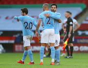 Manchester City's Ilkay Gundogan, Kyle Walker and Bernardo Silva celebrate after the match.