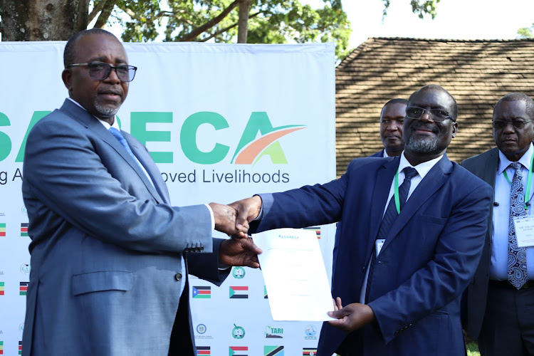 Agriculture and Livestock Development Cabinet Secretary, Mithika Linturi receives handover notes from his Uganda counterpart Frank Tumwebaze when he was installed as the Chairman, Council of Patron Ministers for Strengthening Agricultural Research in Eastern and Central Africa (ASARECA) at Safari Park Hotel, Nairobi on February 15,2024.