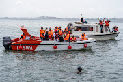 Supporters of Akinrodoye Samuel cheer while he swims the 11.8km stretch of the Third Mainland Bridge in Lagos, Nigeria.