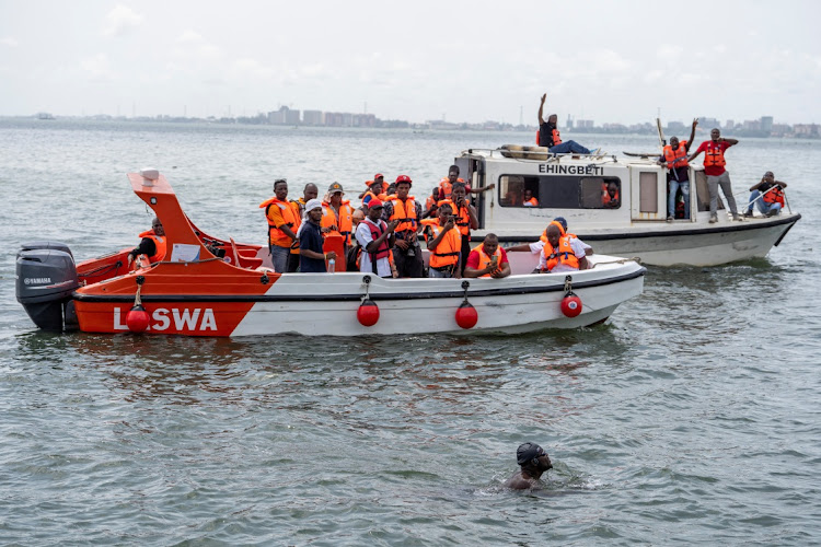 Supporters of Akinrodoye Samuel cheer while he swims the 11.8km stretch of the Third Mainland Bridge in Lagos, Nigeria.