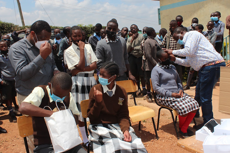 Kenya Society of Deaf Children officials fitting students with hearing aids.
