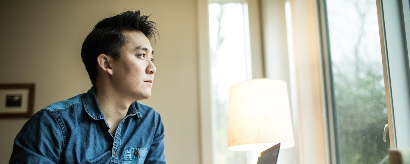 Man working from home looking out his window