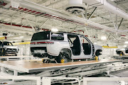 Rivian R1S SUVs being transferred between stations on the trim line in general assembly.