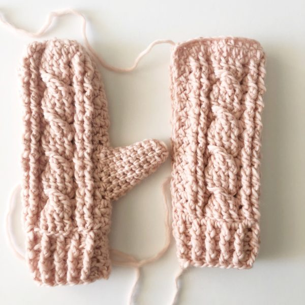 cabled crochet mittens on white background