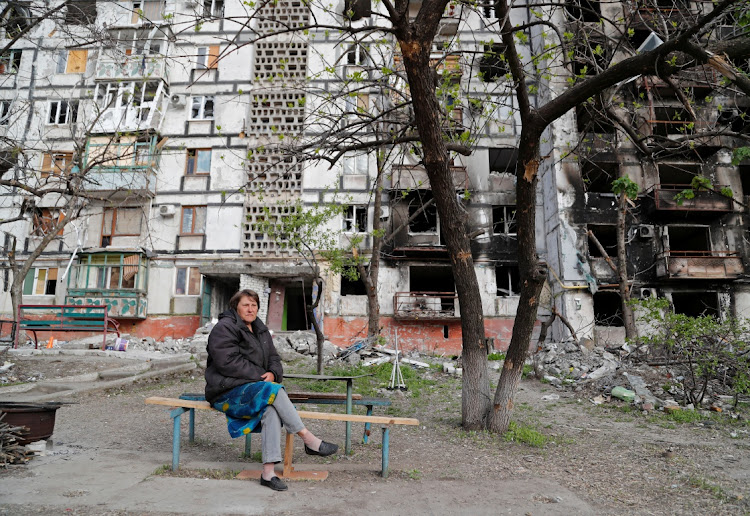 Local resident Tatiana Bushlanova, 64, sits on a bench near an apartment building heavily damaged during Ukraine-Russia conflict in the southern port city of Mariupol, Ukraine on May 2, 2022.