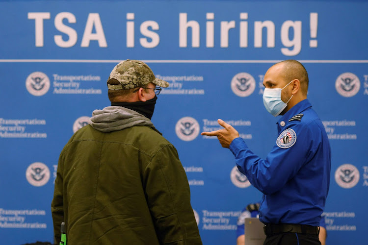 A job seeker talks to a representative from the TSA at a jobs fair at Logan International Airport in Boston, Massachusetts, the US, December 7 2021. Picture: BRIAN SNYDER/REUTERS