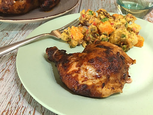 A nice grilled Caribbean Jerk Rotisserie Chicken served with potato salad.