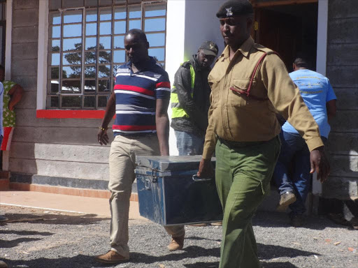 Officers carry a box full of fake currencies in Kwihota village, Ruiru, yesterday /JOHN KAMAU