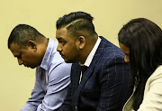 Preshalin Naidoo sitting with his parents during a court proceeding.