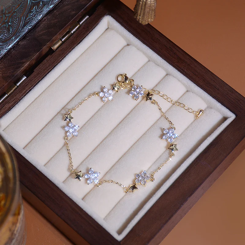 Bracelet étoile à cinq branches et fleur en zircon micro-incrusté. Un bijou raffiné pour femmes, apportant une touche d'éclat et de féminité à votre poignet.