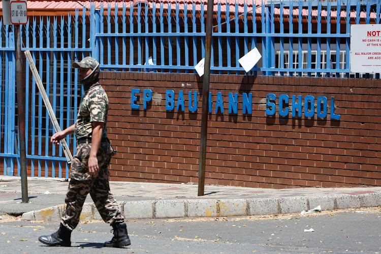 A private security guard monitors the scene at EP Bauman Primary in Mayfair.