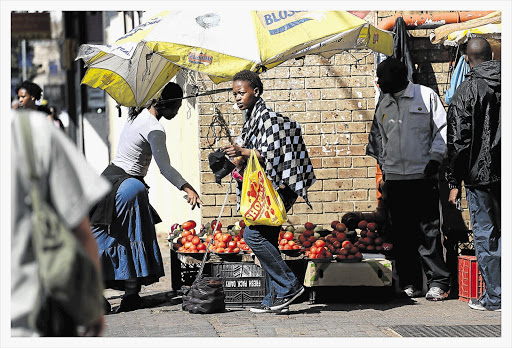 Shoppers and hawkers congregate outside a Shoprite store in Rosettenville, Johannesburg. The retailer has announced that it will prioritise job creation in the coming year