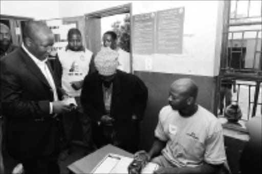 BIG DAY: ANCYL's Julius Malema shows his ID to an IEC official before he cast his vote at Mponegele Primary School in Seshego in Limpopo. 23/04/09. Pic. Elijar Mushiana. © Sowetan.